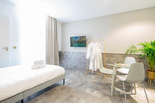 1 dormitorio con 1 cama, mesa y sillas en Newly build Utopia The Den Apartment 7-Minutes From Rotterdam City app2, en Schiedam