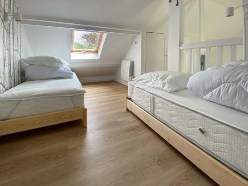 une chambre avec deux lits et une fenêtre dans l'établissement La Maison Bleue avec Jardin à Mers-Les-Bains, à Mers-les-Bains