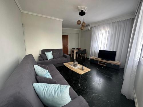 sala de estar con sofá y TV en Agnanti Apartment en Kavala