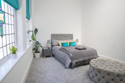 a bedroom with a bed and a large window at #20 Grimston St 2 bedroom apartment near Hull New Theatre in Hull