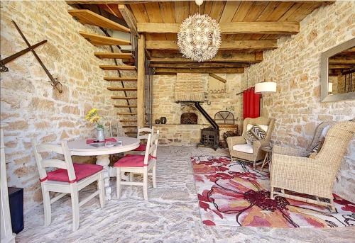 La Belle Etoile في Cuzance: غرفة معيشة مع طاولة وكراسي ومدفأة