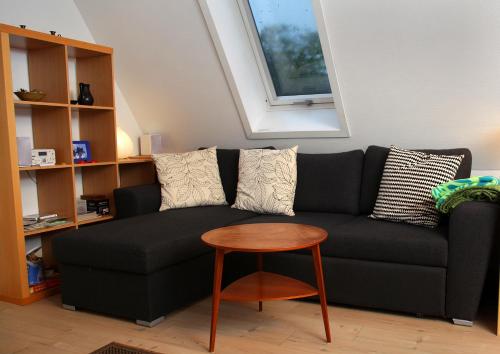a living room with a black couch and a table at Bed & Breakfast Horsens in Horsens