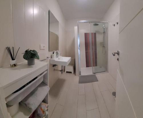 a white bathroom with a shower and a sink at ATICO con vistas al mar a 100 metros de la playa in Torre de Benagalbón