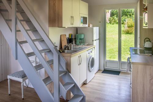 une cuisine avec un escalier menant à une buanderie dans l'établissement La Maison Bleue avec Jardin à Mers-Les-Bains, à Mers-les-Bains