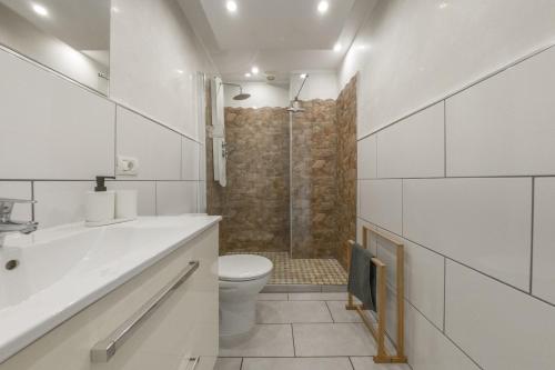 a white bathroom with a toilet and a shower at Playa Honda LA in Playa de las Americas