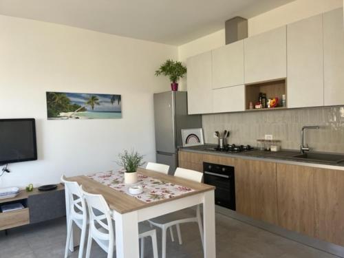 een keuken met een tafel, stoelen en een aanrecht bij Profumo di Mare new 2023 in Alcamo Marina