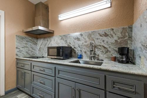 a kitchen with a sink and a microwave at Country Inn Sonora in Sonora