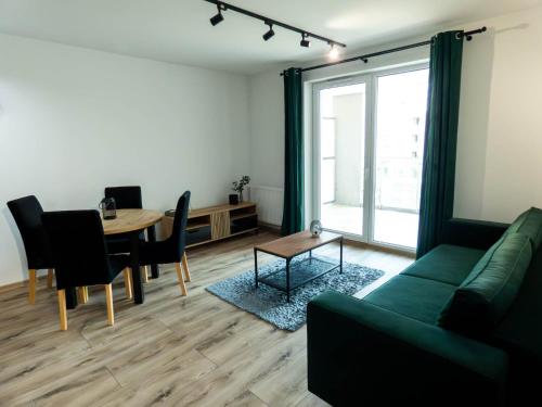 - un salon avec un canapé vert et une table dans l'établissement Apartament Flat 33 Suwałki, à Suwałki