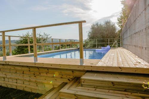 a wooden deck with a pool in a backyard at Pieve di San Jacopo a Mucciana in San Casciano in Val di Pesa