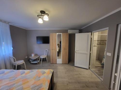 ein Schlafzimmer mit einem Bett und ein Zimmer mit einem Tisch in der Unterkunft Casa Berzelor in Sînmartin