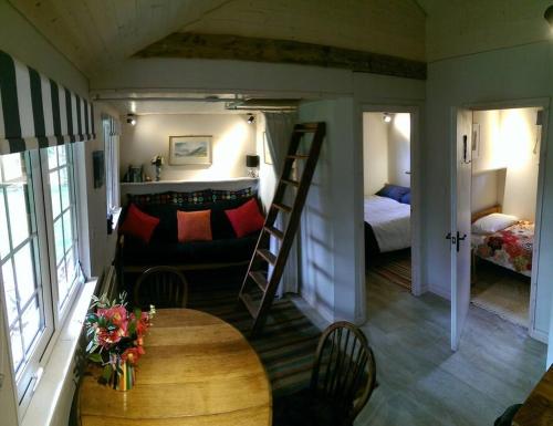 a room with a room with a bunk bed and a table at Secluded cosy cabin near town centre in St Austell