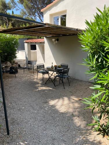 a patio with a table and chairs and a building at Home Cassis - Maison Les Calanques - Piscine chauffée à 30c in Cassis