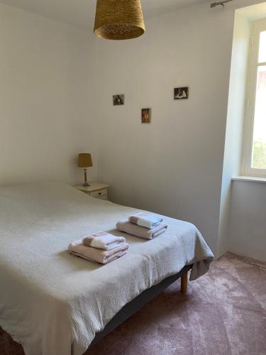 een slaapkamer met een bed met twee handdoeken erop bij Maison confortable in Espéraza
