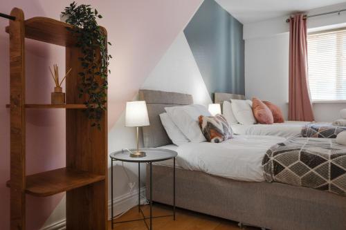 a bedroom with a bed and a table with a lamp at CEFAS Apartments Manchester - Free Parking - City Centre in Manchester