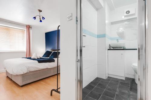 a bedroom with a bed and a bathroom with a shower at CEFAS Apartments Manchester - Free Parking - City Centre in Manchester