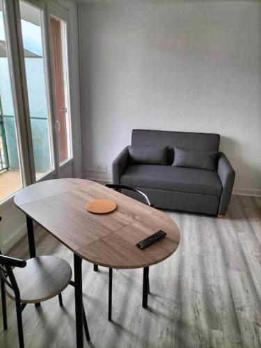un salon avec une table basse et un canapé dans l'établissement Appartement avec balcon et parking privé, à Roanne