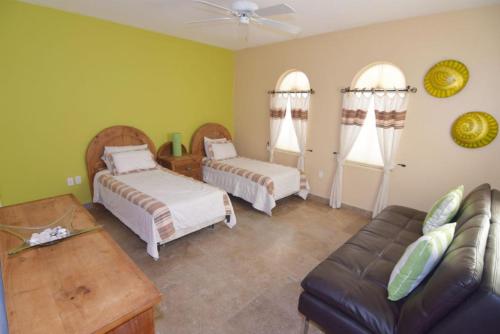 a living room with two beds and a couch at Condo 23-4 Baja Family Retreat, Upscale Beach Resort Condo in Playa El Paraíso