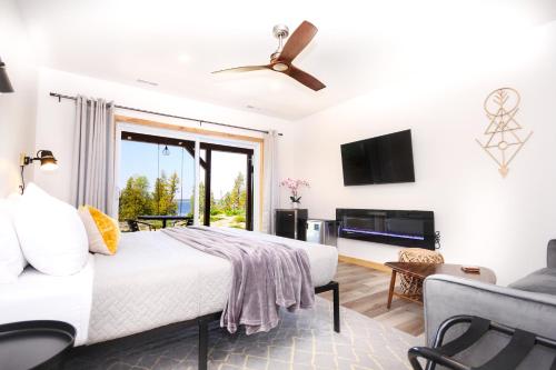 a white bedroom with a bed and a tv at Stone Cove Waterfront Adults Only B&B in Tobermory