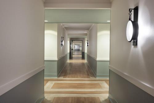 a hallway with green walls and wood floors at The Anza-a Calabasas Hotel in Calabasas