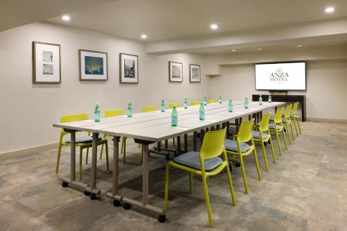 a long table and chairs in a room with a screen at The Anza-a Calabasas Hotel in Calabasas