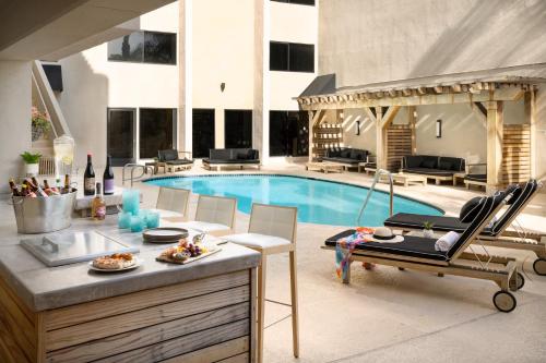 a living room with a pool and a table and chairs at The Anza-a Calabasas Hotel in Calabasas