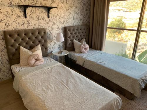 a bedroom with two beds and a window at Villa 96 Taghazout Bay in Taghazout