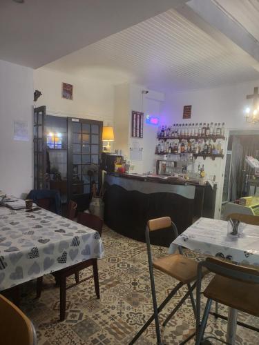 una sala da pranzo con due tavoli e un bar di LES TERRASSES DE L'ALLIER a Monistrol-dʼAllier