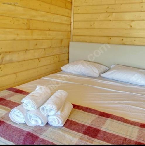 Una cama en una habitación con toallas enrolladas. en Yılmaz camping, 