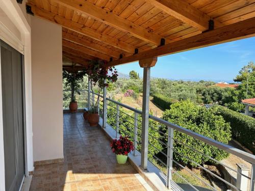 einen Balkon eines Hauses mit Holzdach in der Unterkunft Vaso's Paradise in Eretria