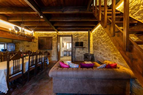 sala de estar con sofá y pared de piedra en RioVerde Agroturismo, en Barcelos