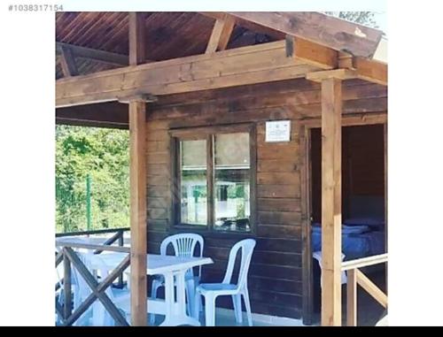 een veranda van een hut met een tafel en stoelen bij Yılmaz camping 