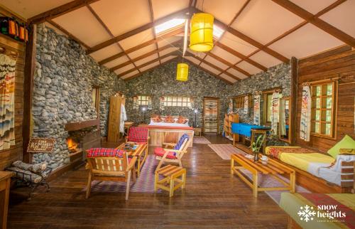 a living room filled with furniture and a stone wall at Snow Heights Lodges in Kasese