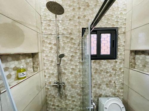 ein Bad mit einer Dusche und einem WC in der Unterkunft Villa meublée à Lome Résidence LES PLURIELLES HESTIA in Lomé