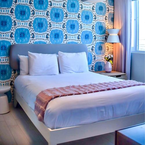 a bedroom with a large bed with a blue and white wall at Trópica Beach Hotel in San Juan