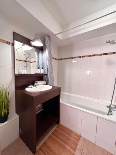 une salle de bain avec un lavabo et une baignoire dans l'établissement B306 Appartement DisneyLand Paris, à Montévrain
