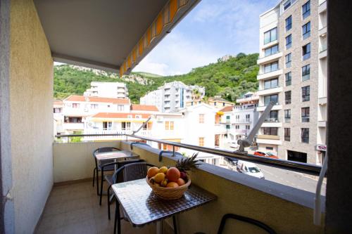 a bowl of fruit on a table on a balcony at Tanja Apartments in Rafailovici