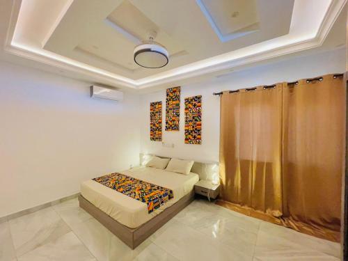 ein Schlafzimmer mit einem Bett und einem Wandgemälde in der Unterkunft Villa meublée à Lome Résidence LES PLURIELLES HESTIA in Lomé