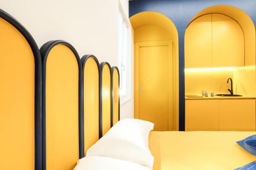 - une chambre avec des murs jaunes et un lit avec des oreillers blancs dans l'établissement Archi Rooms Boutique, à Salerne