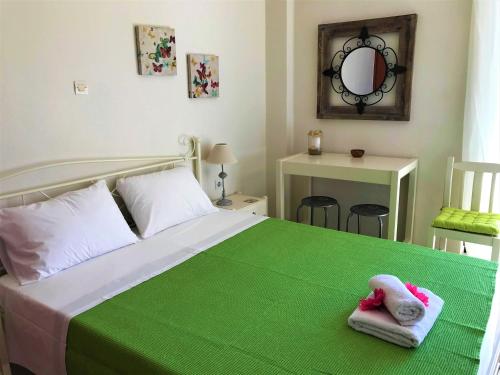 een slaapkamer met een groen bed en handdoeken bij Μελίτατα 19 in Rethimnon