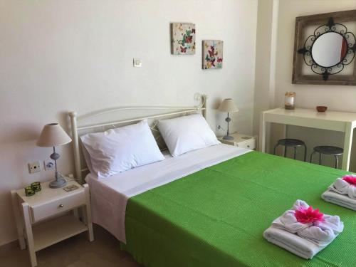 een slaapkamer met een bed met groene lakens en handdoeken bij Μελίτατα 19 in Rethimnon