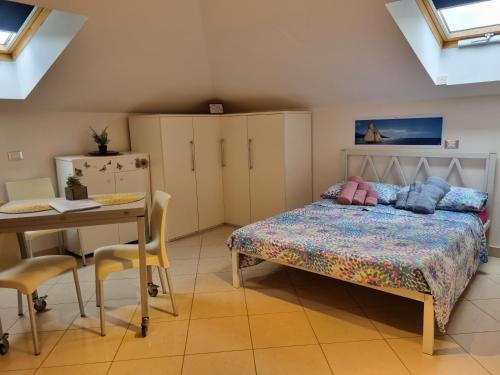 a bedroom with a bed and a table and chairs at La Mansarda di Noi2 in Spotorno