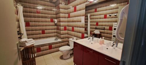 a bathroom with a sink and a toilet and a tub at Alti'Pic Hôtel in Le Mont-Dore