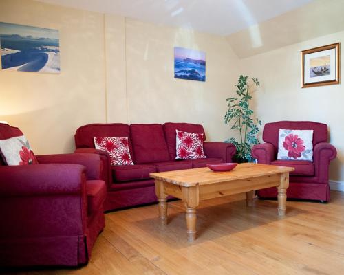 a living room with two purple couches and a coffee table at Slieve League Lodge in Carrick
