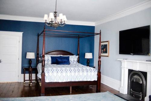 a bedroom with a canopy bed with blue walls at Lakehurst Estate in Cobourg