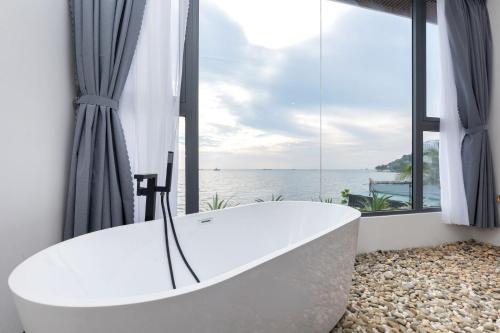 y baño con bañera y vistas al océano. en The Palm Villa 24 Luxury ( 6 Bedroom , Karaoke, Bi-da ) en Vung Tau