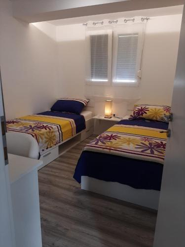 a bedroom with two beds and a window at H&F apartmani in Vir