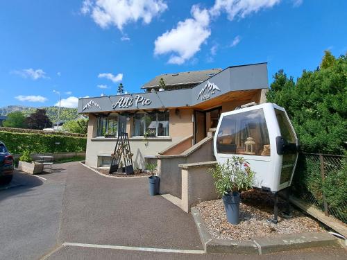 a building with a van parked outside of it at Alti'Pic Hôtel in Le Mont-Dore