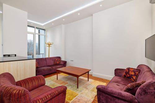 a living room with two purple couches and a table at Beyaz Köşk Geyve in Geyve