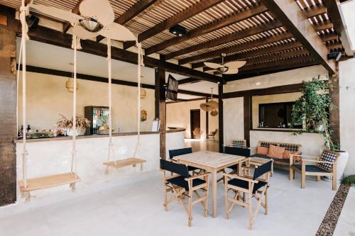 a dining room with a wooden table and chairs at Pousada Zama in Camburi