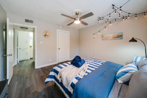 a bedroom with a blue bed and a ceiling fan at Austin - Down by the Sea - 1 br Apt near SoCo in Austin
